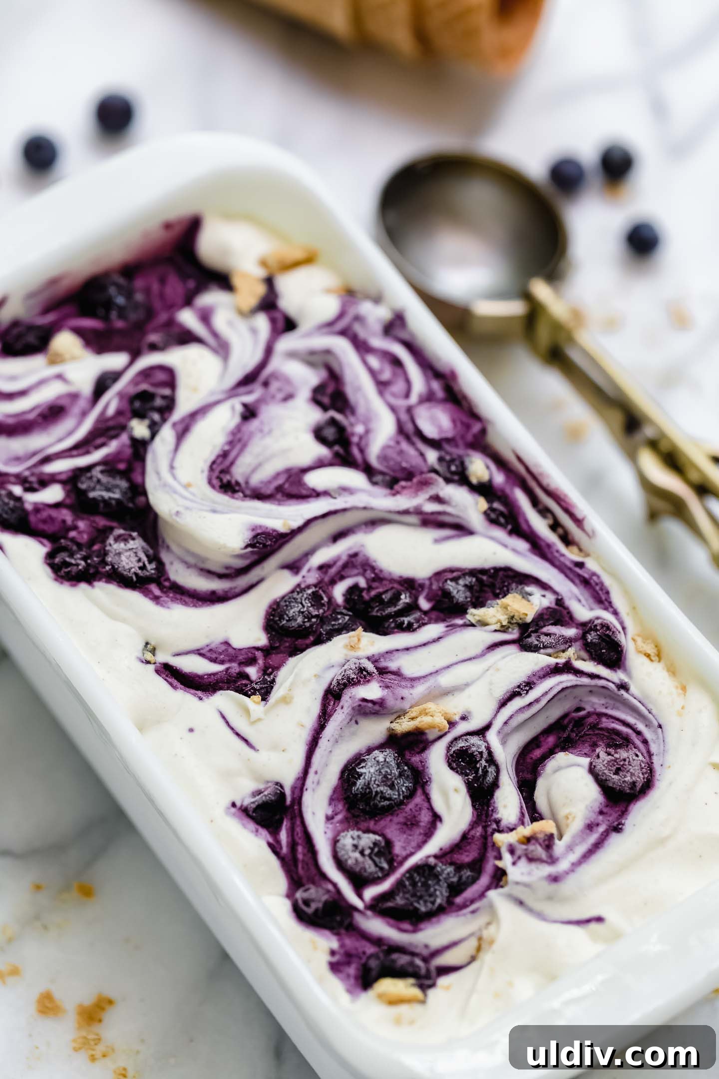Blueberry Pie Ice Cream Recipe — Creamy Homemade Dessert 5 Blueberry Pie Ice Cream in a container.