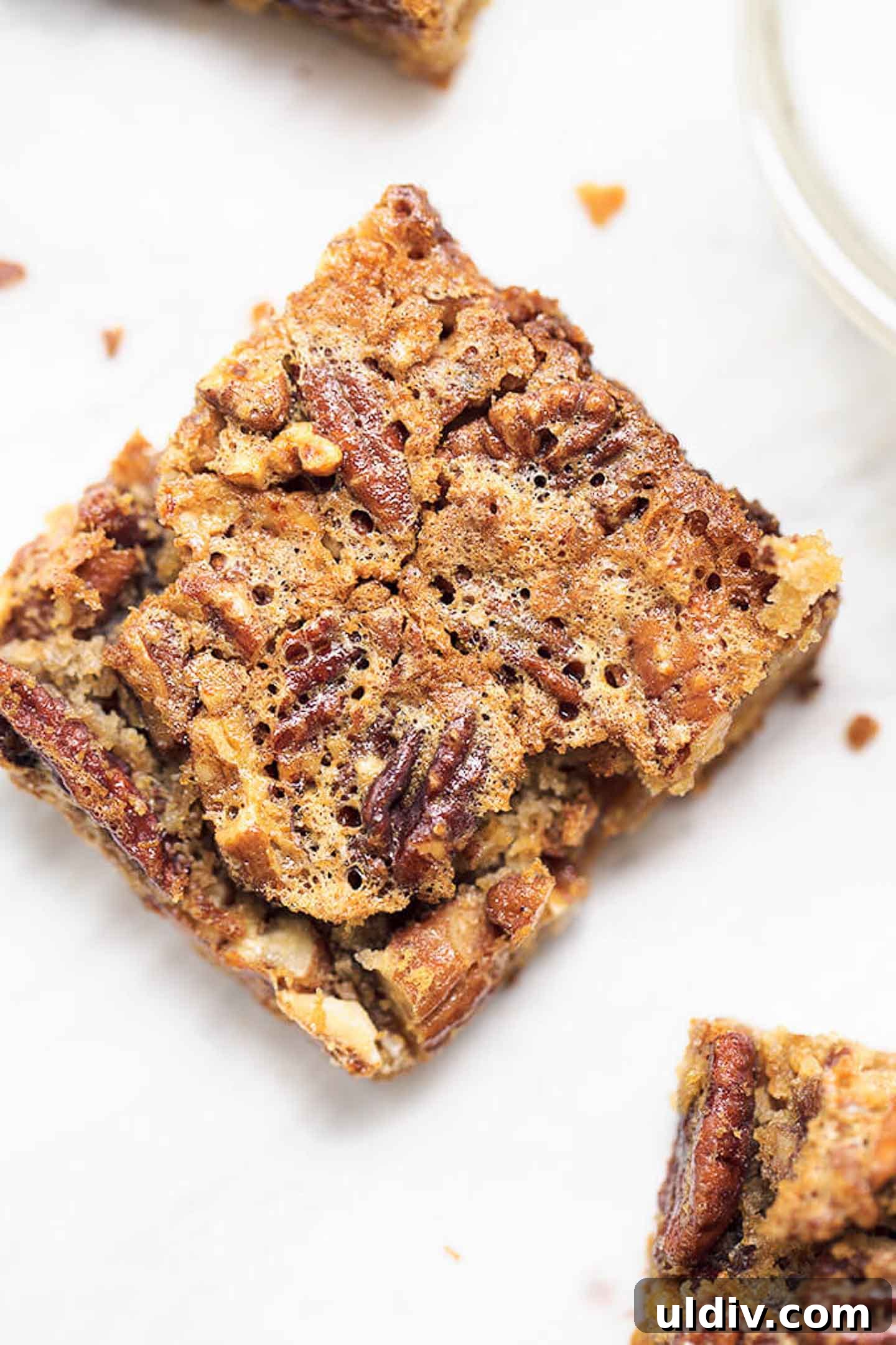 Chewy Pecan Pie Bars with Buttery Shortbread Crust 2 A pecan pie bar on a serving plate.