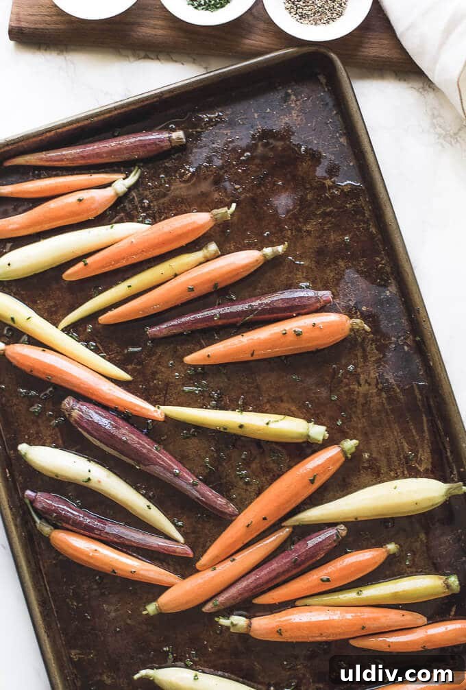 Sweet and Savory Oven-Roasted Carrots with Honey and Herbs 3 Carrots on a baking sheet.