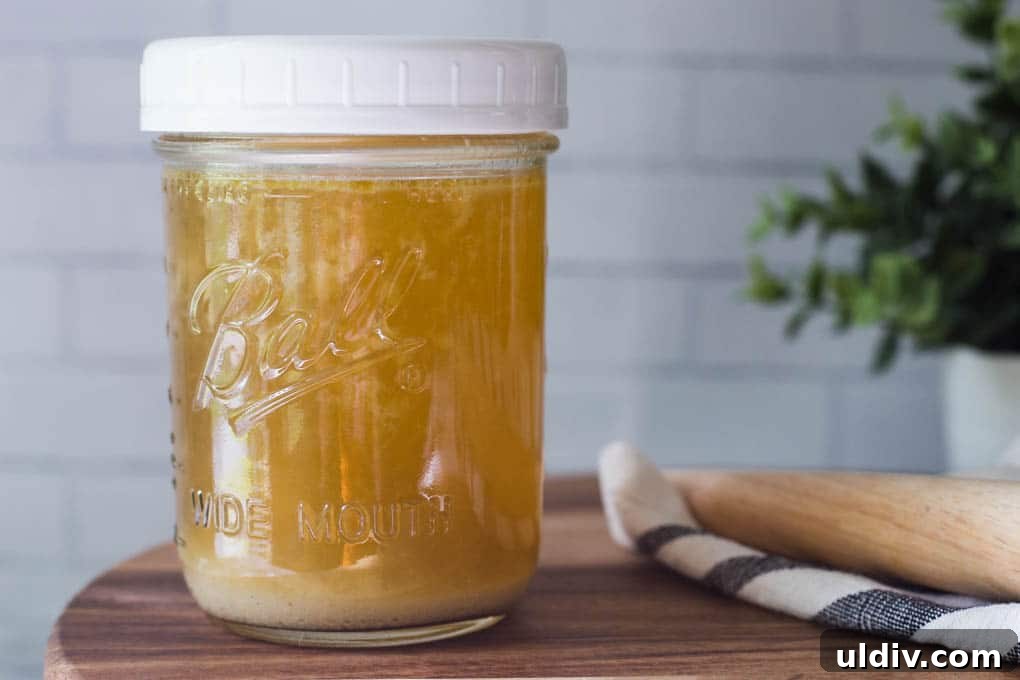 a jar of chicken stock Chicken stock in a mason jar.