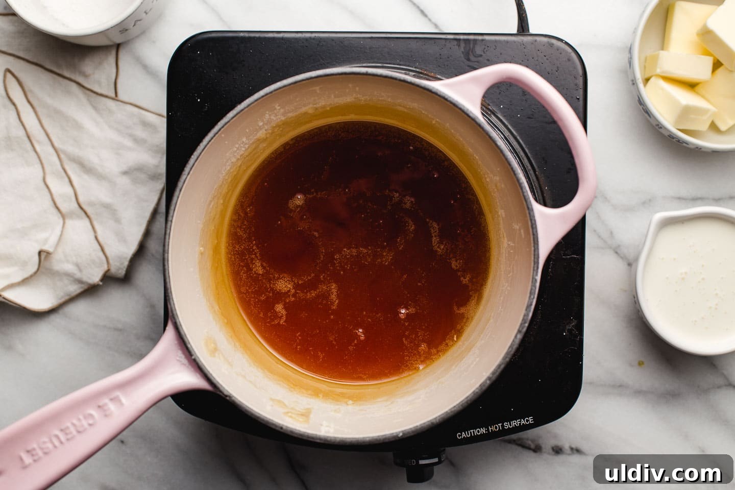 Homemade Salted Caramel Sauce Recipe for Smooth, Gooey Results 4 Sugar browning in a saucepan.