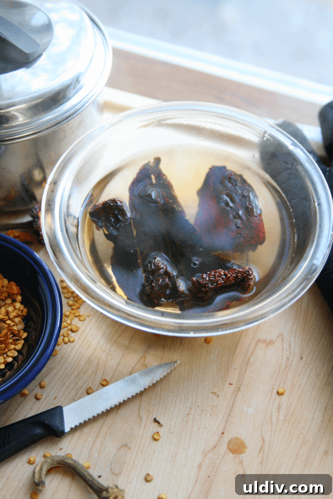 Smoky Ancho Chile Sauce Recipe for Tacos, Marinades & Dips 4 Dried peppers sitting in boiling water.