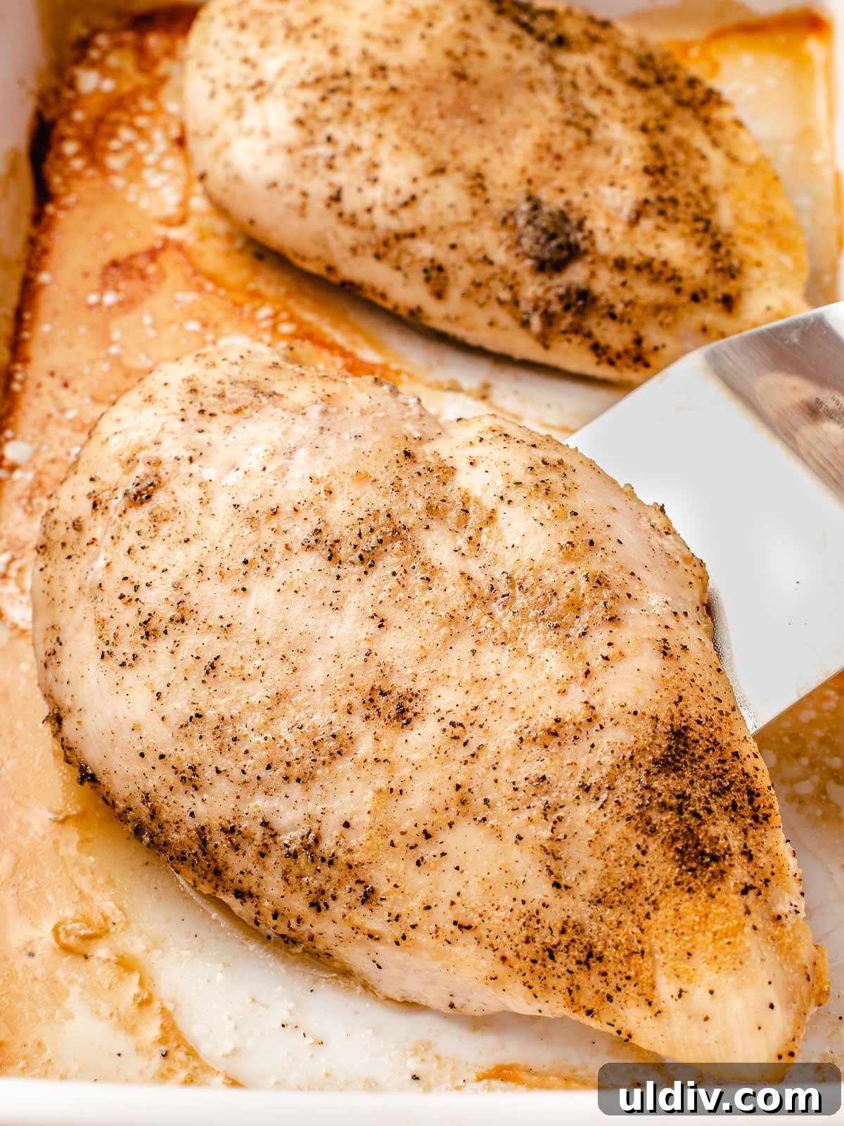 Juicy Oven-Baked Chicken Breasts with Garlic and Herbs 2 Baked chicken breast in a baking dish.