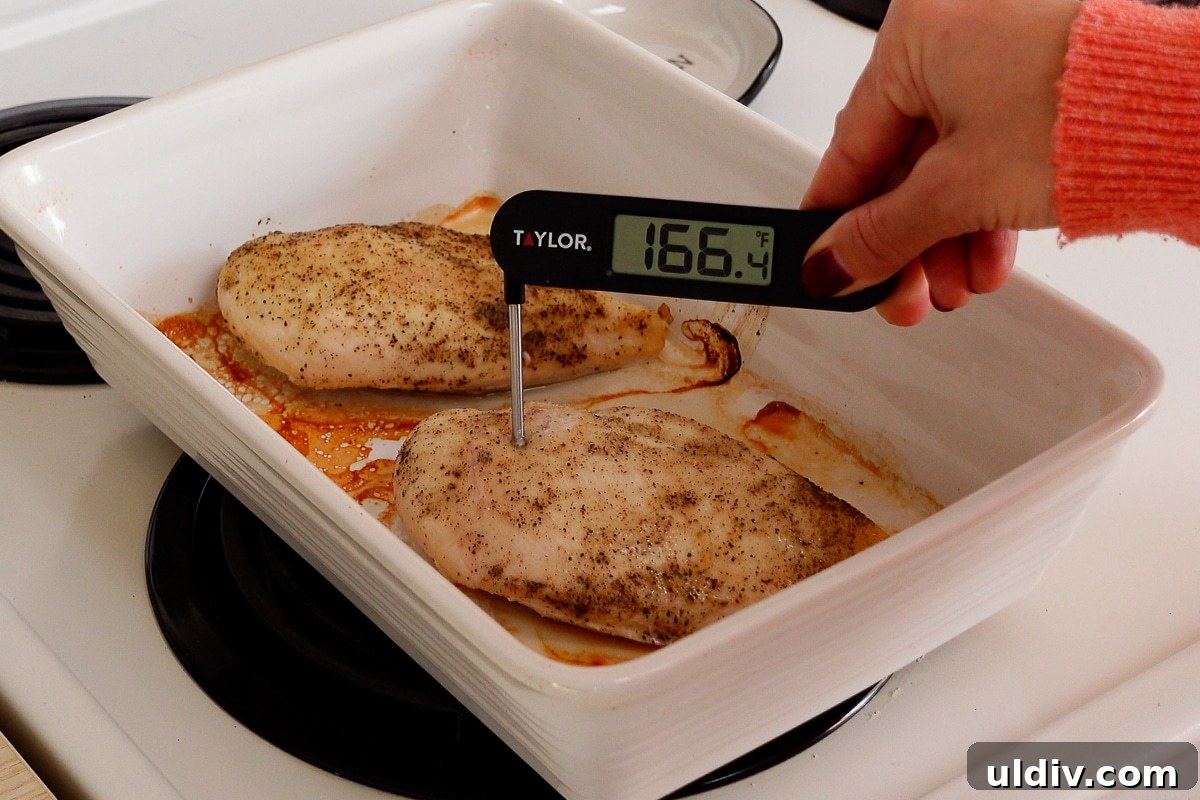 Juicy Oven-Baked Chicken Breasts with Garlic and Herbs 5 A woman checking the internal temperature of a chicken breast.