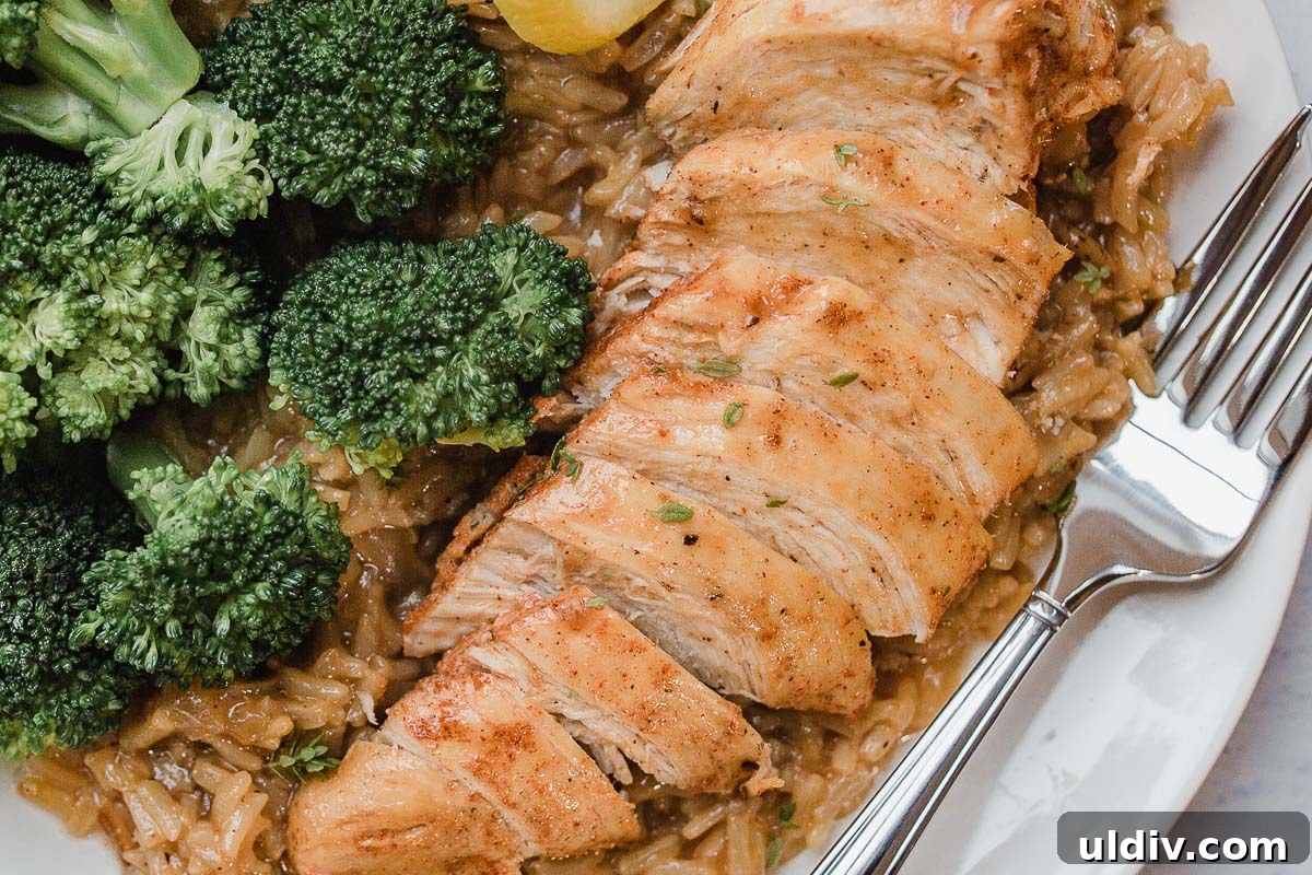 Instant Pot Lemon Herb Chicken with Flavorful Rice 3 Close up photo of sliced chicken over a bed of rice.