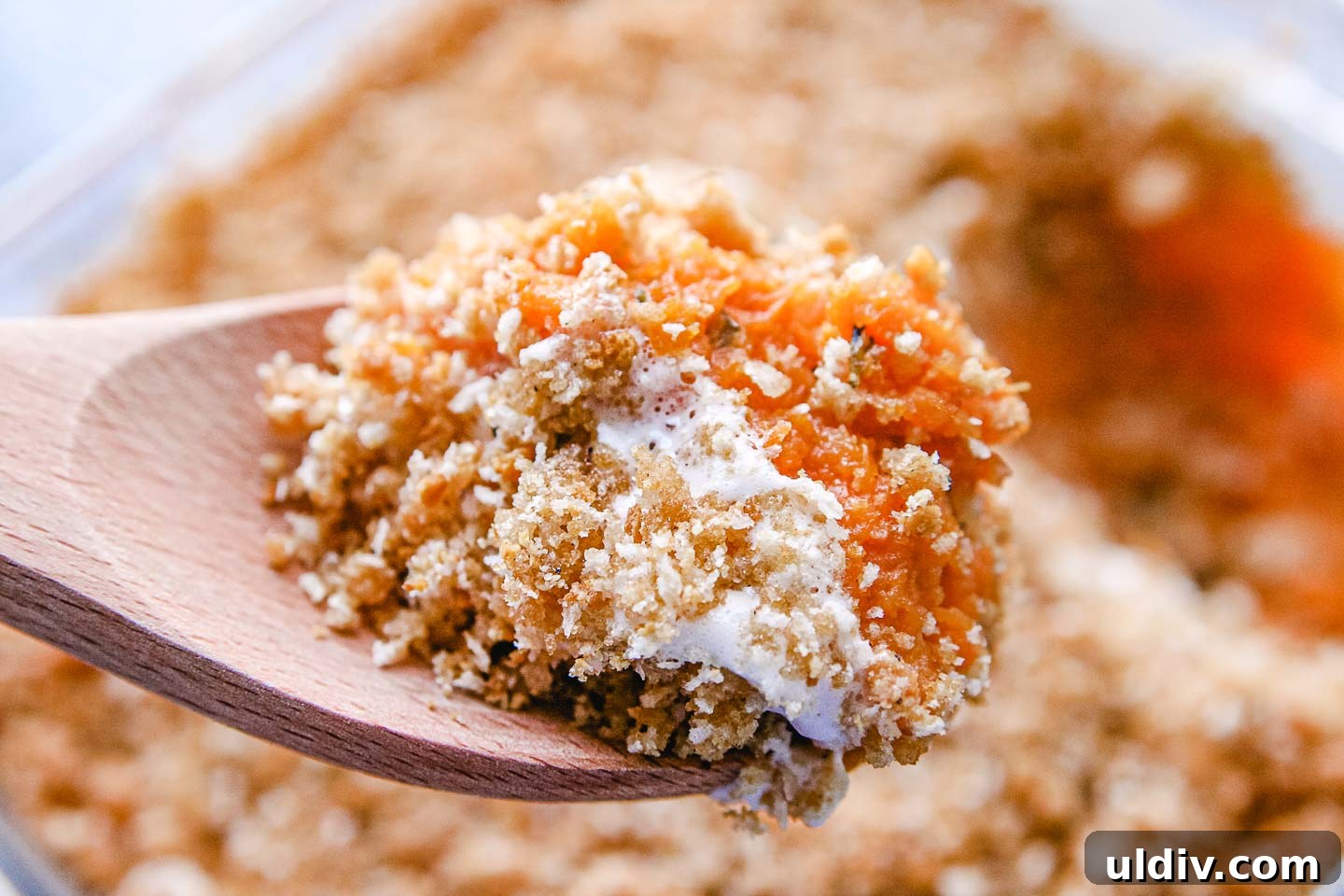 Creamy Sweet Potato Casserole with Crunchy Pecan Topping 7 A scoop of sweet potato casserole on a spoon.
