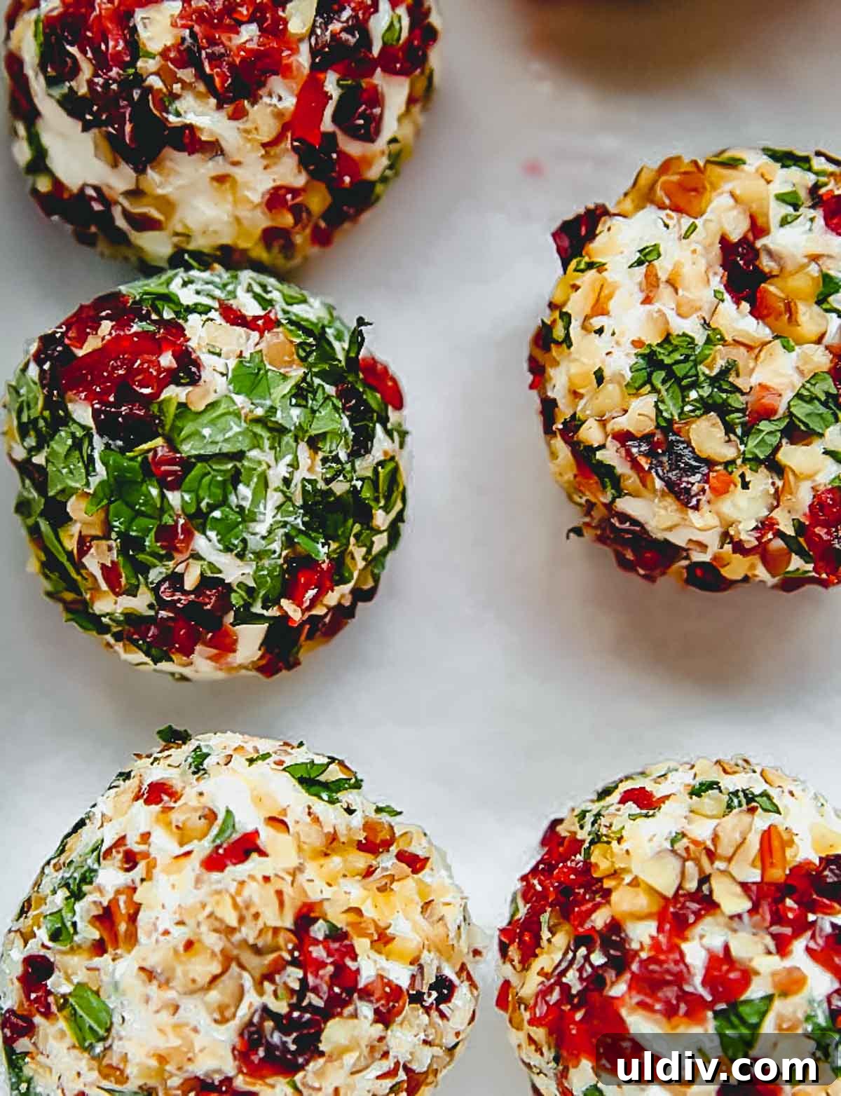 Savory Goat Cheese Truffles: Creamy Appetizer Bites for Parties 2 Goat cheese truffles on a piece of parchment paper.