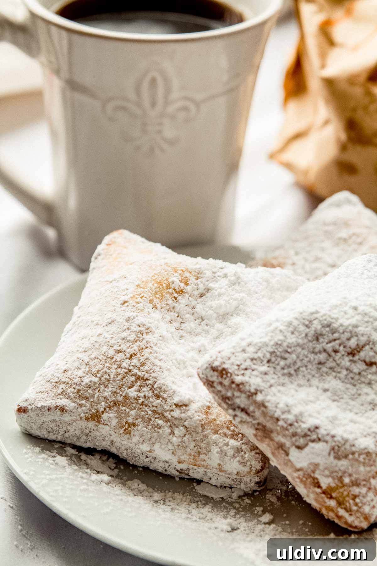 New Orleans Beignets: Classic Café-Style Powdered Sugar Treats 2 3 New Orleans style beignets on a plate.