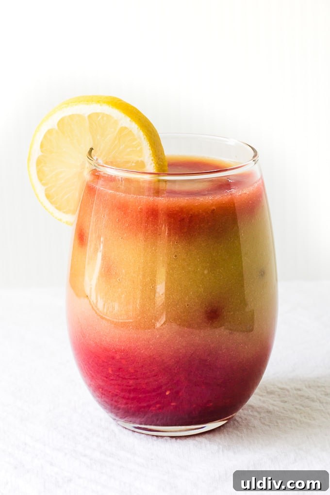 Sunrise Detox Smoothie is a light and refreshing way to start your day! Sunrise detox smoothie in a glass with a lemon slice.