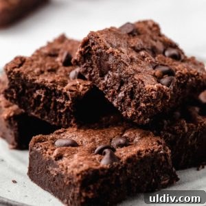 A stack of homemade brownies on a plate.