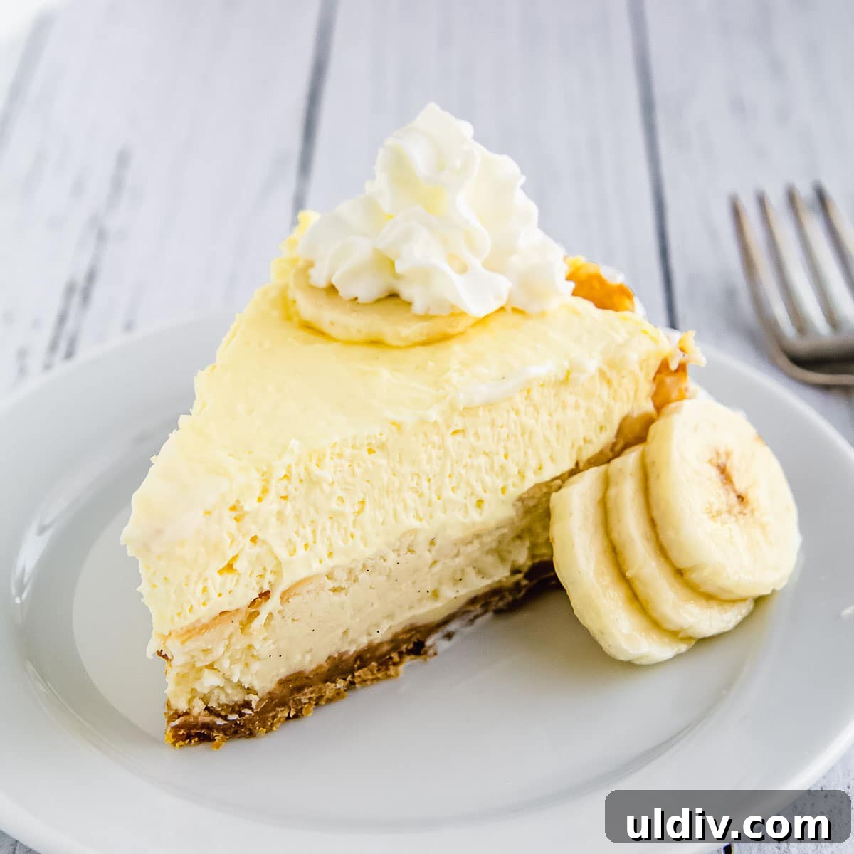 Banana Cream Pie Cheesecake Recipe: Creamy Layered Dessert Guide 2 A slice of banana cream cheesecake on a plate.